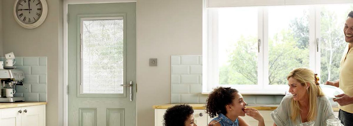 Family in a kitchen enjoying their new composite door, fitted by Paradise Windows