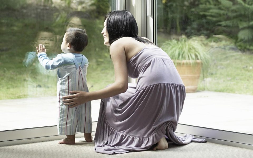 Replacing windows in spring banner - Woman and child looking out of window into garden