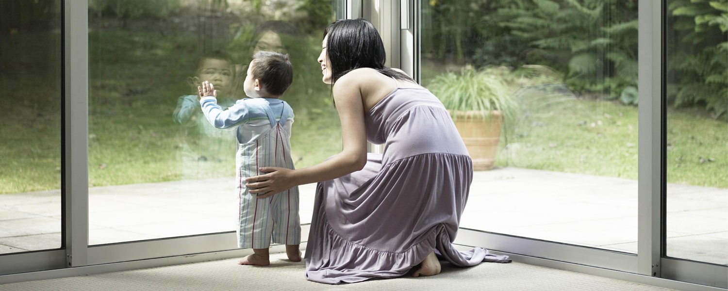 Replacing windows in spring banner - Woman and child looking out of window into garden